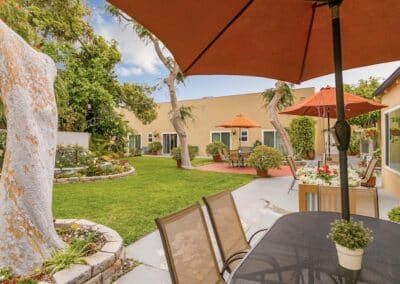 Beautiful courtyard with trees, plants and sun shades with seating